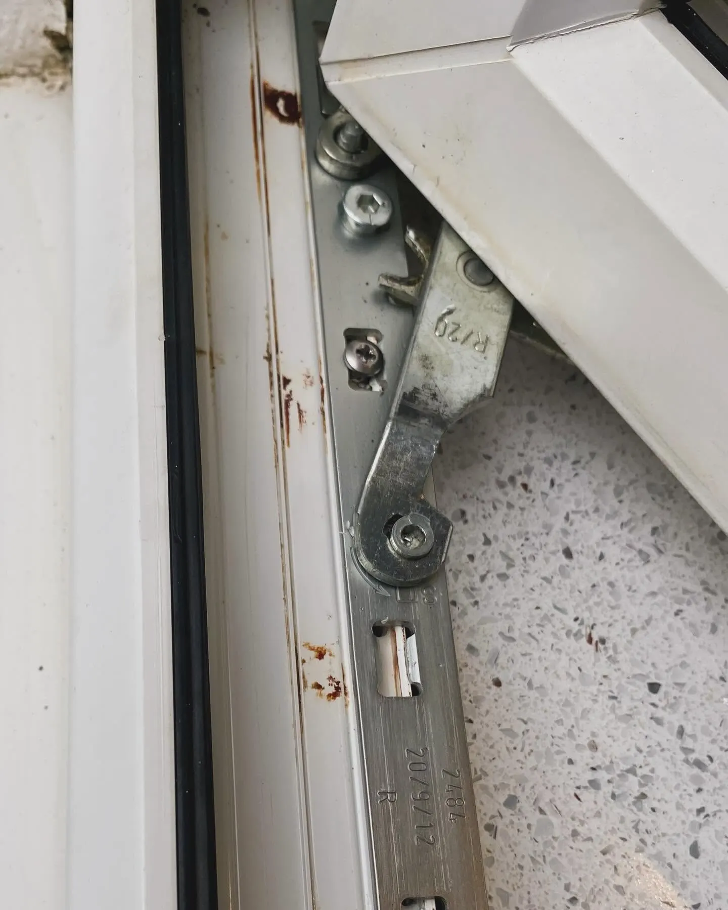 A corroded uPVC window friction hinge being replaced