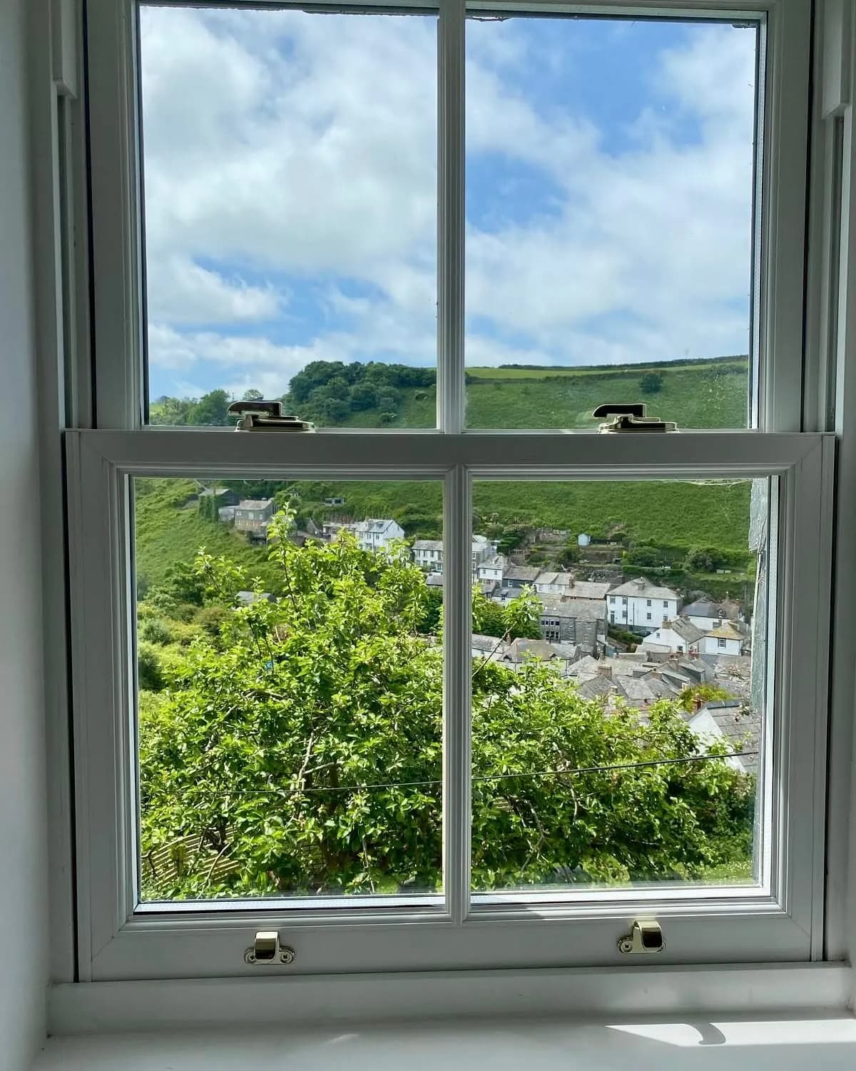 A repaired window looking over a Cornish valley