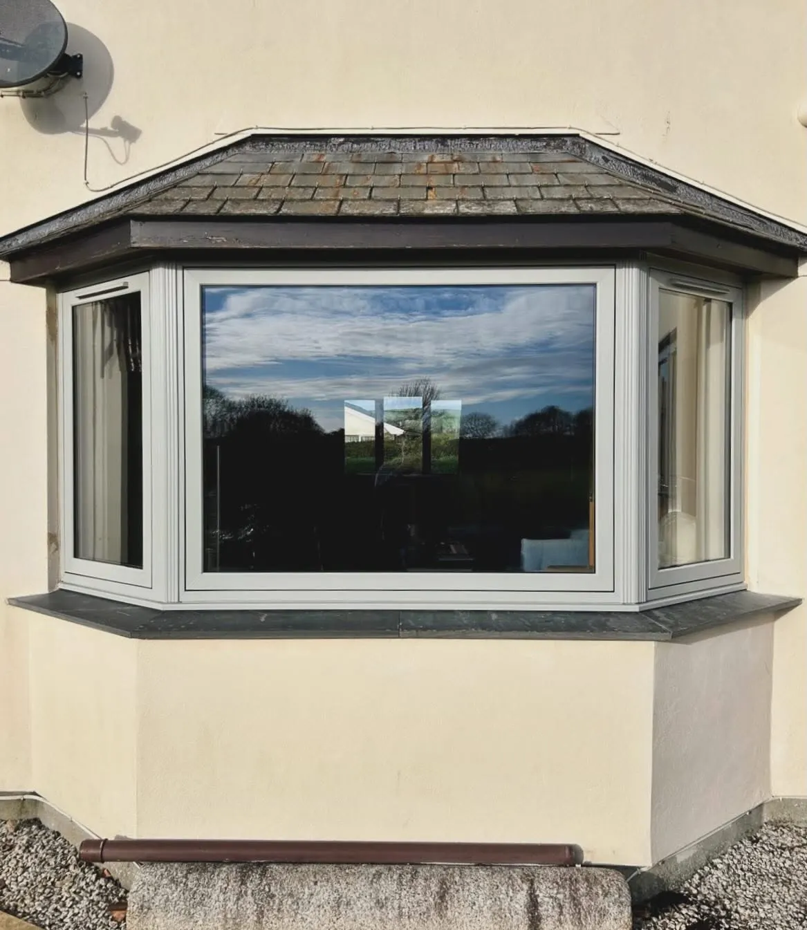 A replacement uPVC bay window on a rendered Cornish house